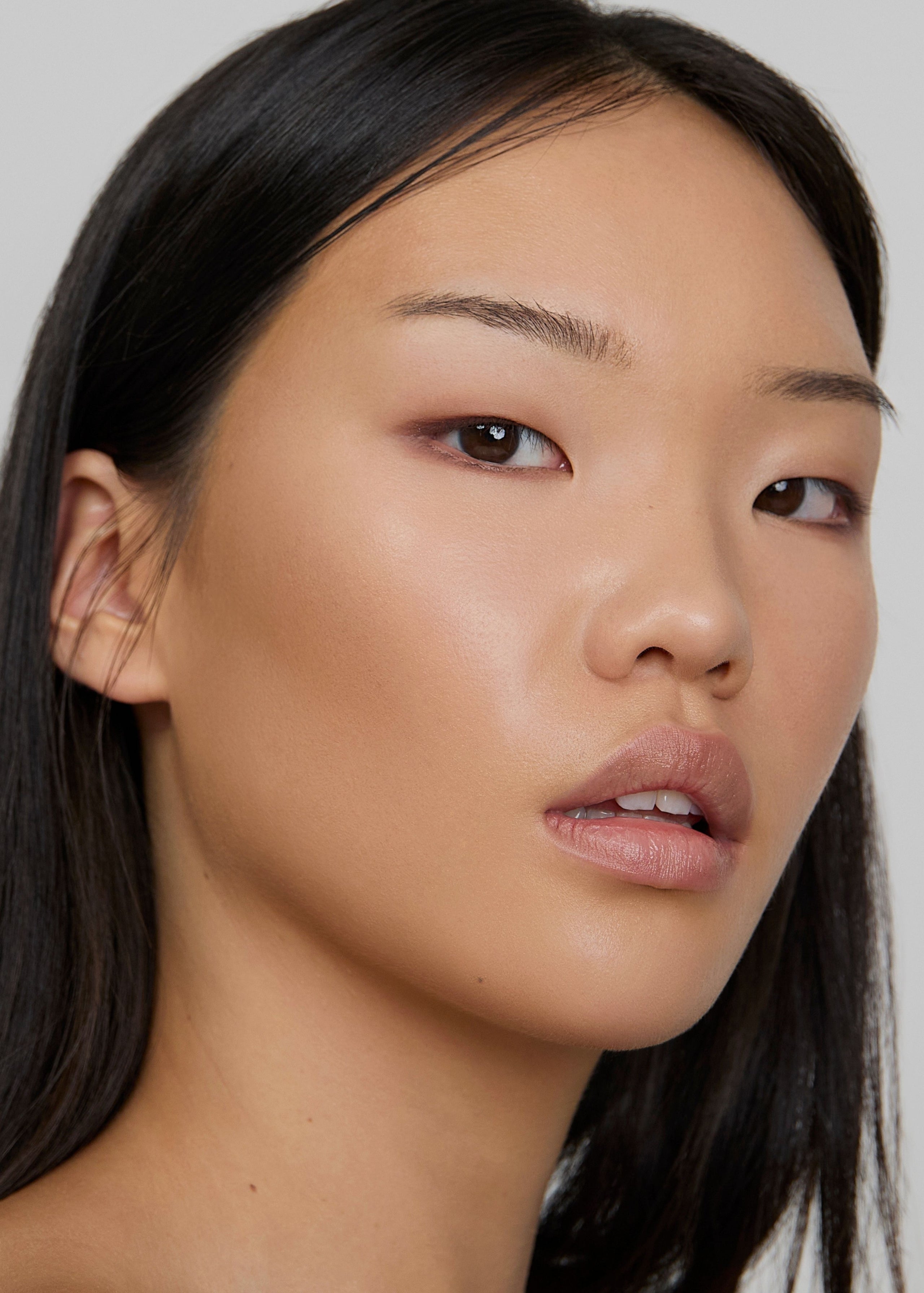 Close-up portrait of model with soft, luminous makeup.