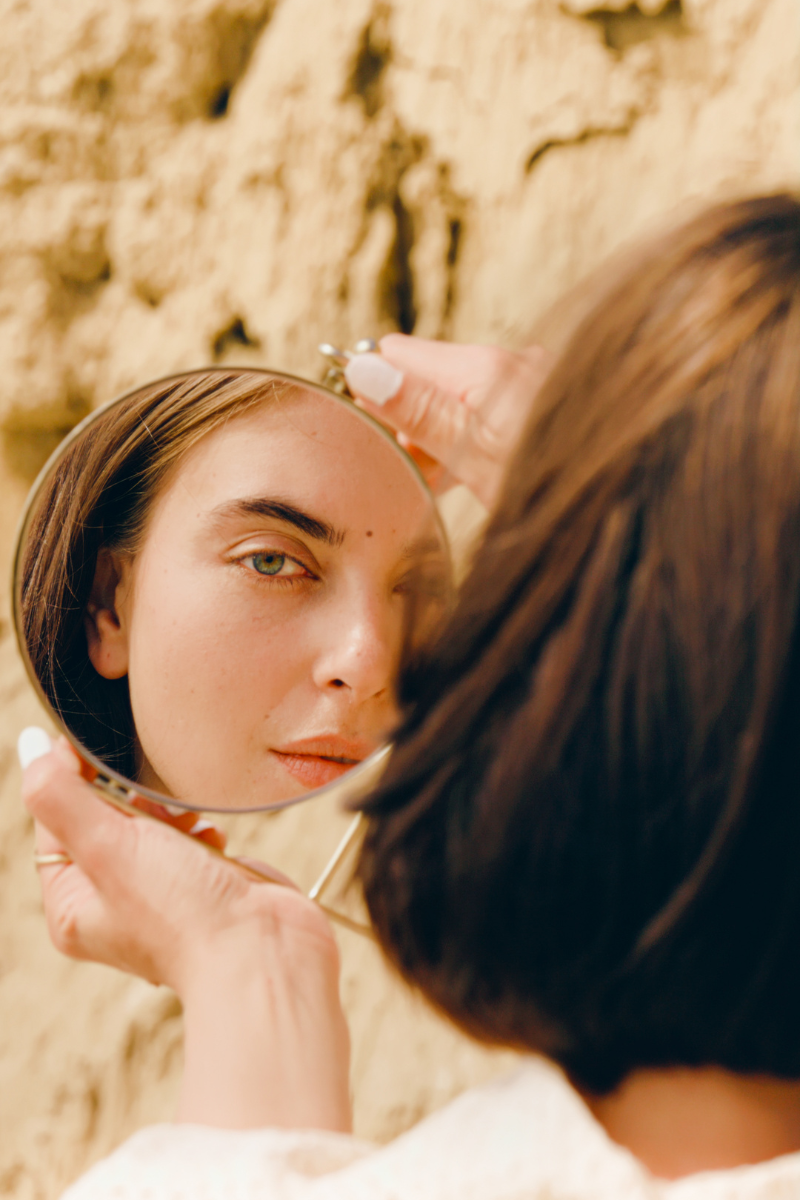 Woman holding a mirror on the beach
