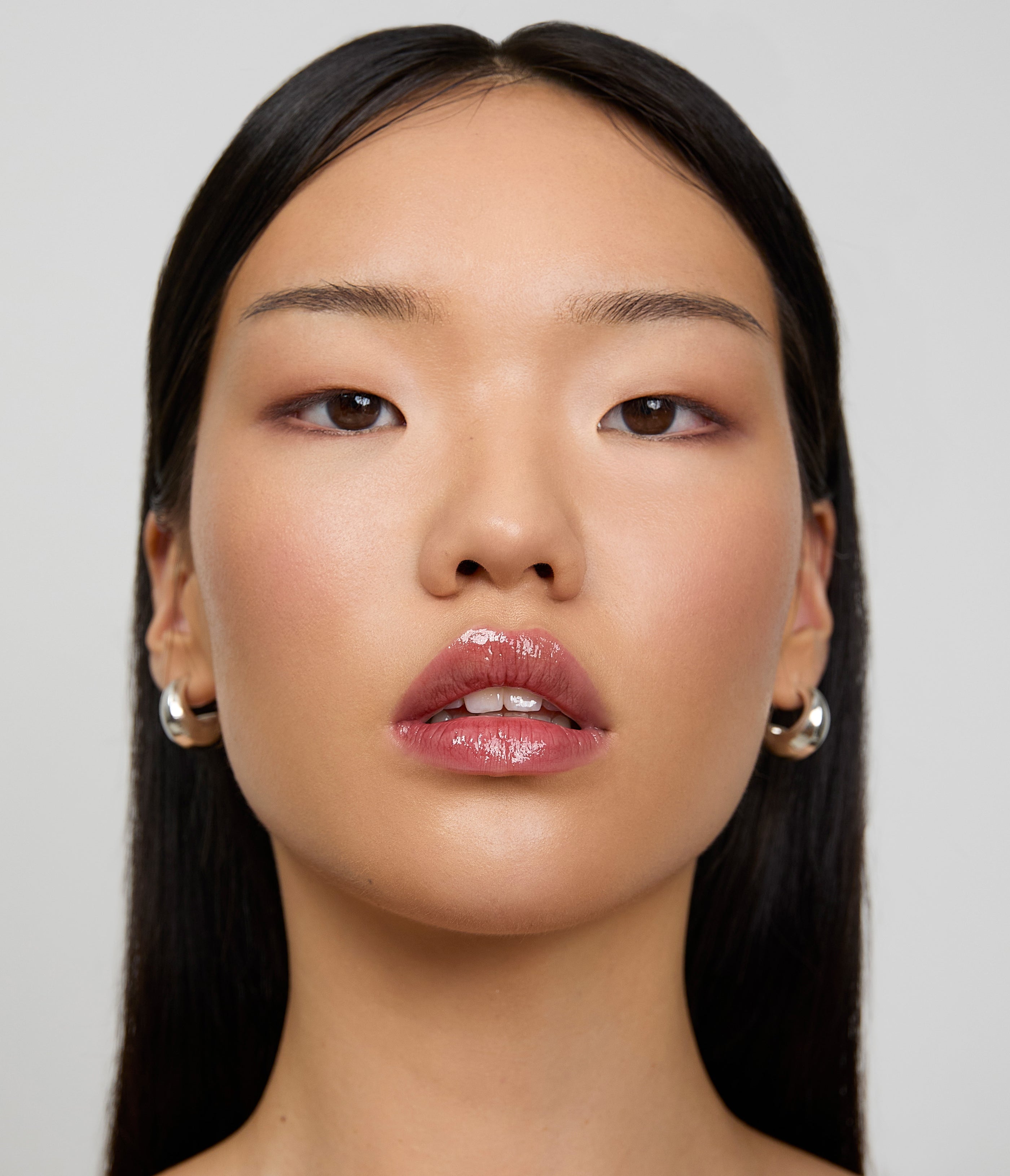 Model wears a light application of Aleph Aura Gloss Ember